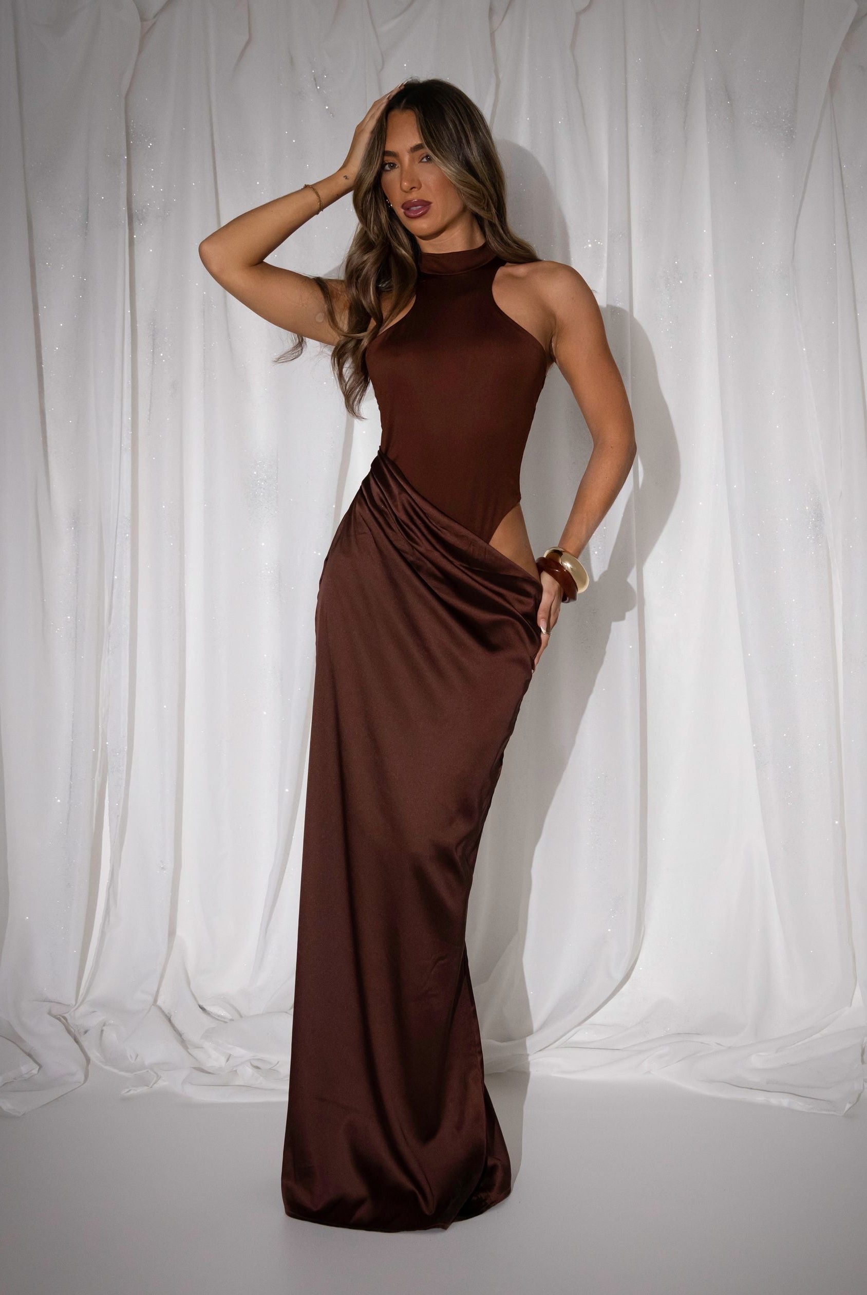 Women's brown maxi dress with built in brown bodysuit and racer style neckline and satin skirt starting at waistline. Cut out detail on the thigh and maxi length skirt.